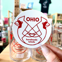 Load image into Gallery viewer, a hand holding a round vinyl sticker with a white background and red ohio cardinals design
